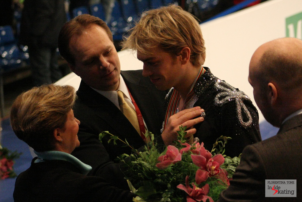 A touching moment at the end of the ice dancing event: the coach' hand on Nick' s heart